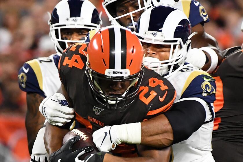 CLEVELAND, OHIO SEPTEMBER 22, 2019-Rams Aaron Donald stops Nick Chubb for a loss inthe 1st quarter at First Energy Stadium in Cleveland Sunday. (Wally Skalij/Los Angeles Times)