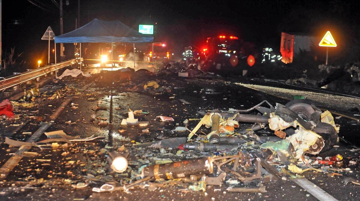 The wreckage of a U.S. military AH-64 Apache helicopter is strewn along a road in Wonju, South Korea, on Monday.