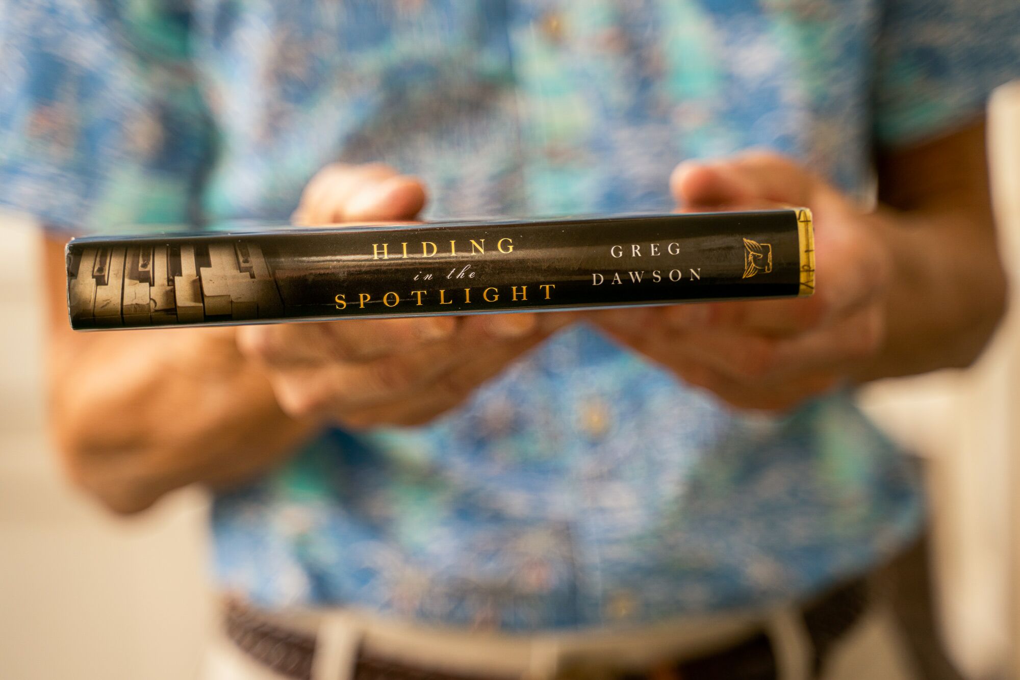 A closeup of a book spine held by a man.