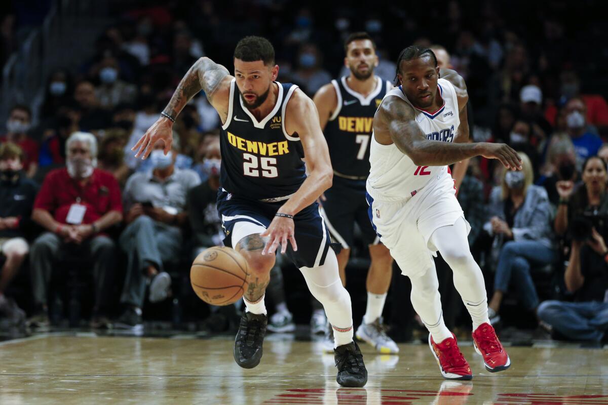 Denver Nuggets guard Austin Rivers drives the ball away from Clippers guard Eric Bledsoe.