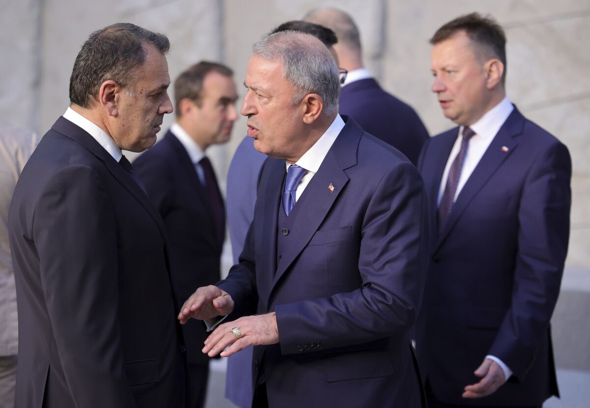 Turkish Defense Minister Hulusi Akar, center, speaks with Greek Defense Minister Nikolaos Panagiotopoulos during a group photo of NATO defense ministers at NATO headquarters in Brussels, Thursday, June 16, 2022. NATO defense ministers gathered Thursday for talks focusing on bolstering forces and deterrence along the military alliance's eastern borders to dissuade Russia of planning further aggression. (AP Photo/Olivier Matthys)