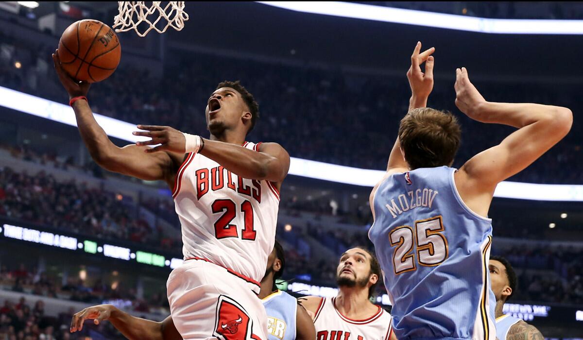 Chicago Bulls guard Jimmy Butler gets past Nuggets center Timofey Mozgov for a layup in the first half.
