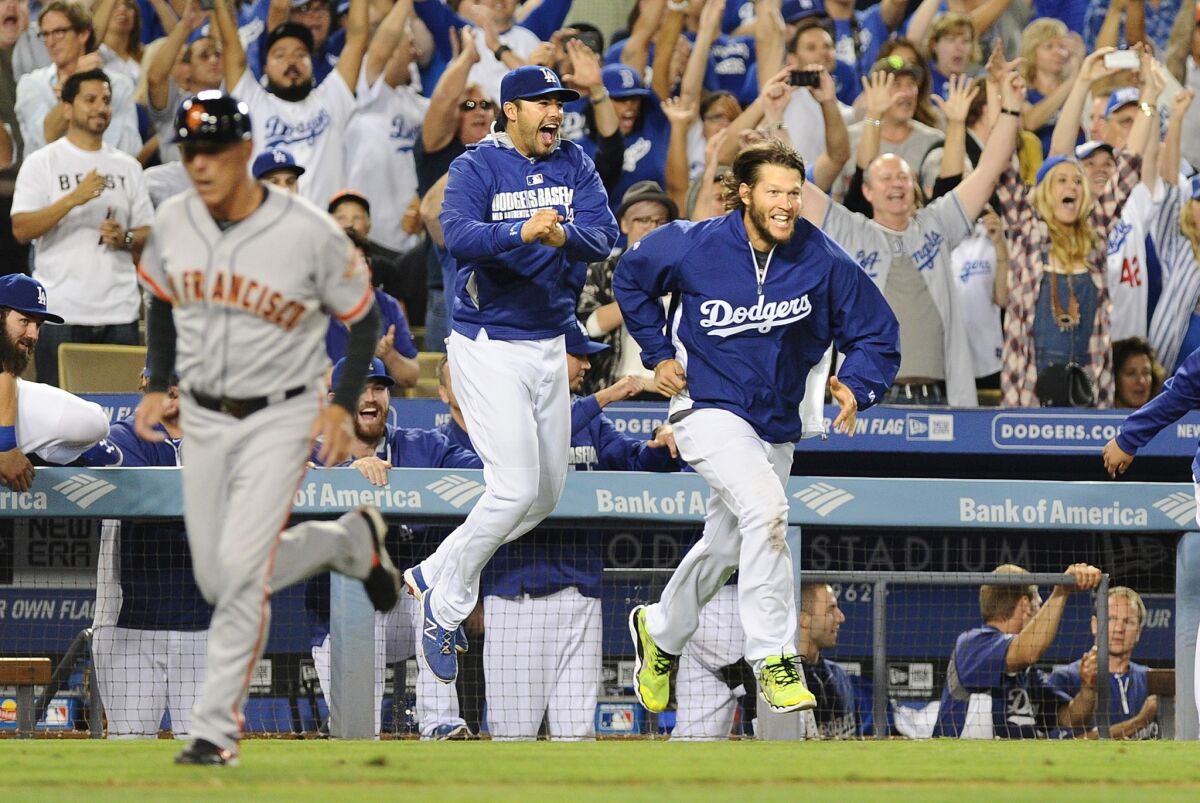 Pitcher Clayton Kershaw, right, and teammates head from the dugout to the field to celebrate their 9-1 victory over the Giants.