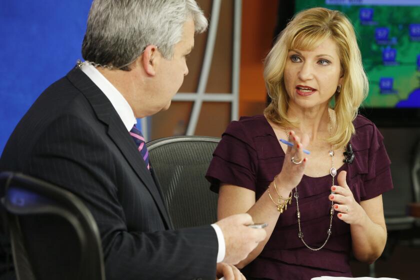 WDBJ-TV anchor Kimberly McBroom talks with guest anchor Steve Grant during the station's early morning newscast in Roanoke, Va., the day after a pair of colleagues were shot to death while on the air.