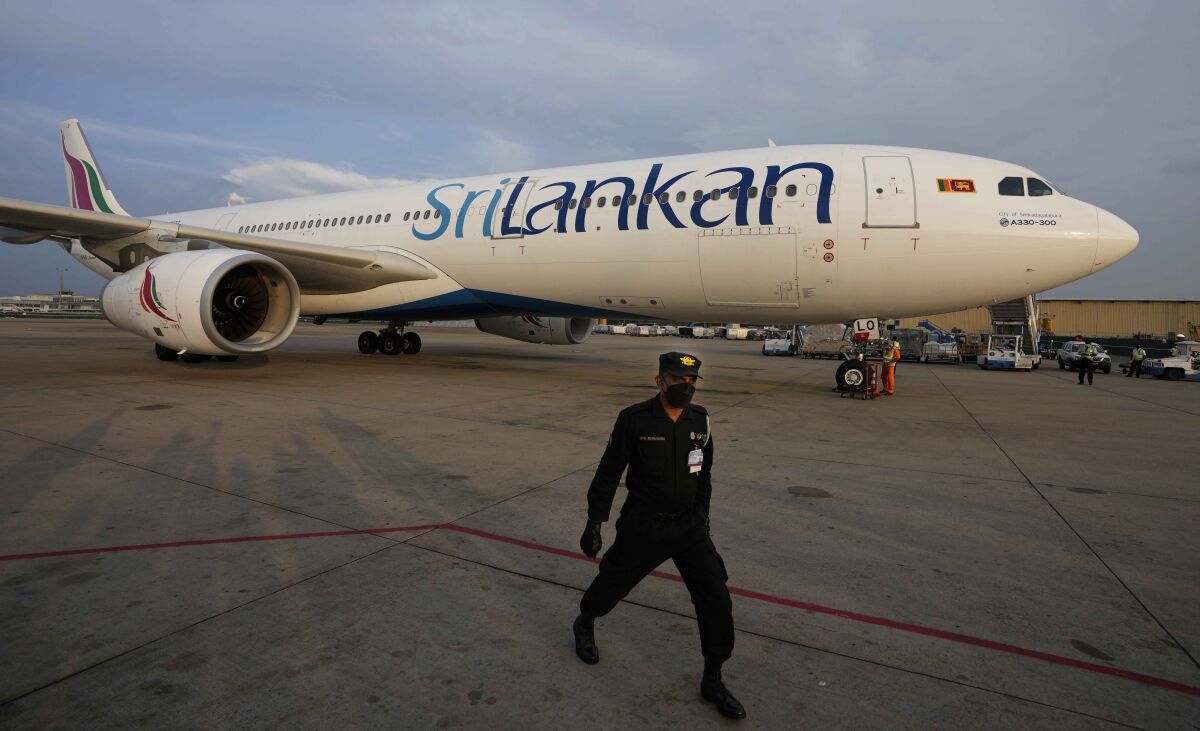 A Sri Lankan Airlines plane carrying remains of Priyantha Kumara, a Sri Lankan employee who was lynched by a Muslim mob in Sialkot arrives as a security officers guards the area in Colombo, Sri Lanka, Dec. 6, 2021. Sri Lanka’s prime minister on Monday proposed to privatize the country’s loss-making national carrier as part of reforms to solve the country worst economic crisis in recent memory. (AP Photo/Eranga Jayawardena, File)