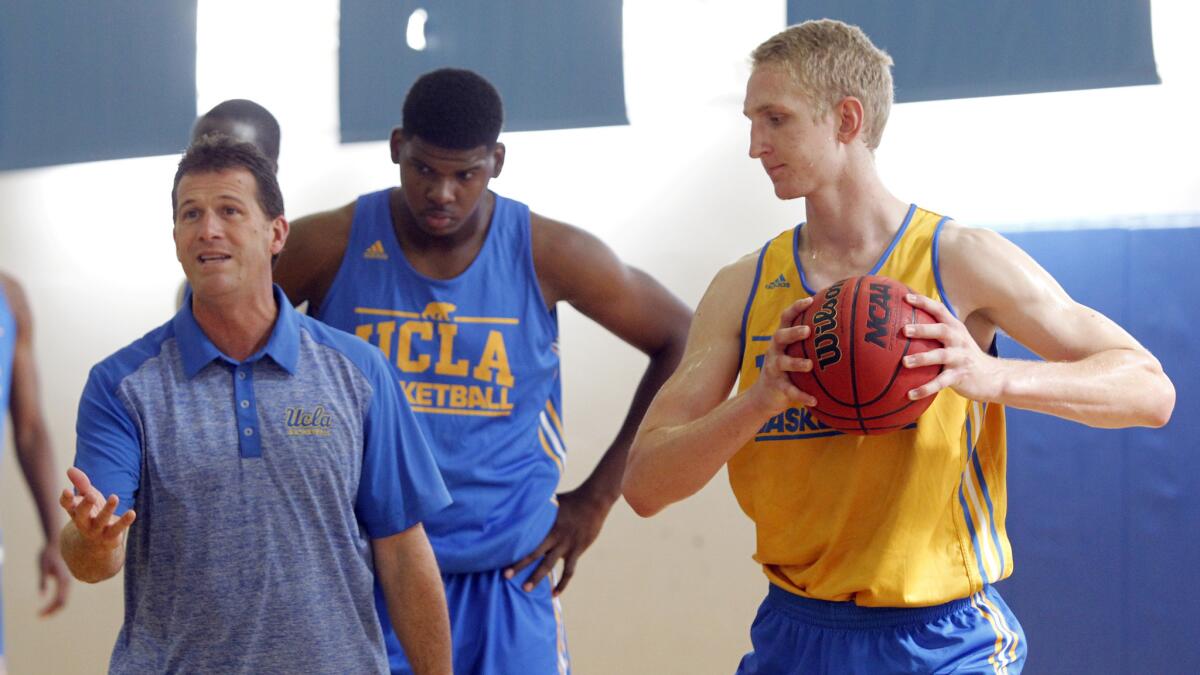 UCLA Coach Steve Alford speaks as Tony Parker, center, and Thomas Welsh look on during a practice session last season.