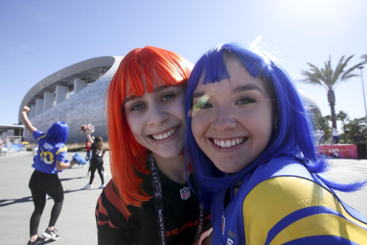 A Rams fan and a Bengals fan pose for a photo outside SoFi Stadium before the start of Super Bowl LVI.