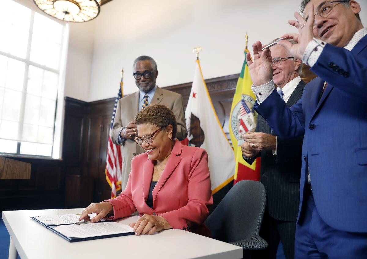 Mayor Karen Bass signs the city budget, which includes at least $250 million for her Inside Safe initiative, on Friday.