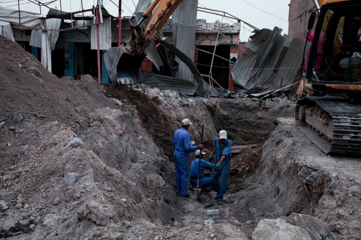 Iraqi workers dig a trench for a new water pipe in Ramadi, Iraq, on March 20, 2016.