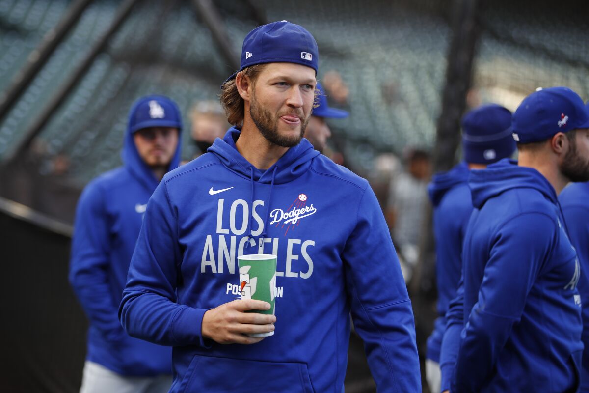 Injured Los Angeles Dodgers pitcher Clayton Kershaw watches as players warm up before Game 1 of a baseball National League Division Series against the San Francisco Giants Friday, Oct. 8, 2021, in San Francisco. (AP Photo/John Hefti)