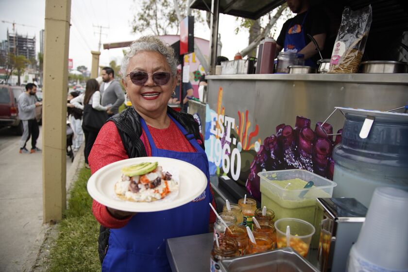 Tijuana, Baja California - April 17: Sabina Bandera owner of La Guerrerense Food Truck holds up a fresh seafood tostada called the Singapour in Hipodromo on Monday, April 17, 2023 in Tijuana, Baja California. (Alejandro Tamayo / The San Diego Union-Tribune)