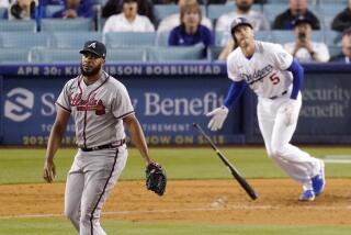 Atlanta Braves relief pitcher Kenley Jansen, left, watches as Los Angeles Dodgers' Freddie Freeman pops out to end the baseball game Tuesday, April 19, 2022, in Los Angeles. (AP Photo/Mark J. Terrill)
