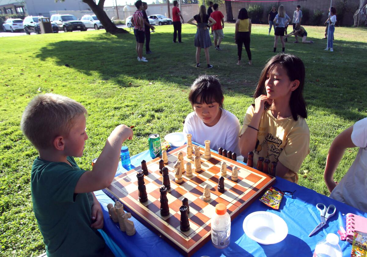 Exchange students from Ota, Japan, play chess during a picnic at Roy Foy Park on Monday, July 29.