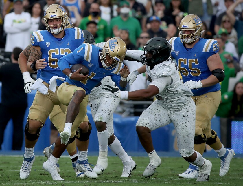 UCLA quarterback Dorian Thompson-Robinson is brought down for a loss by Oregon defensive end Brandon Dorius