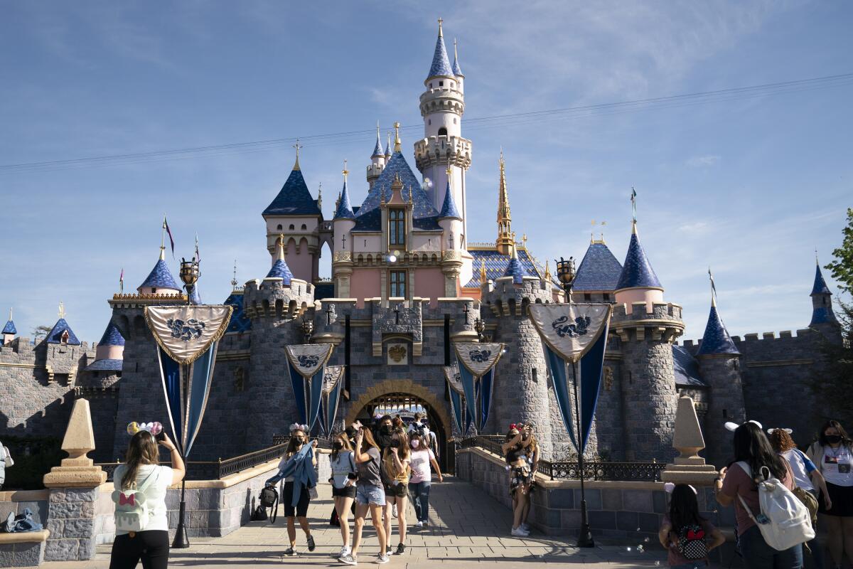 ARCHIVO - Visitantes recorren Disneyland en Anaheim, California, el 30 de abril de 2021.
