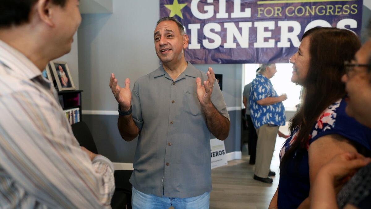 Democrat Gil Cisneros, center, candidate for the 39th Congressional District, speaks to George Lin, left, and Donna Freedman at a meet-and-greet in Rowland Heights.