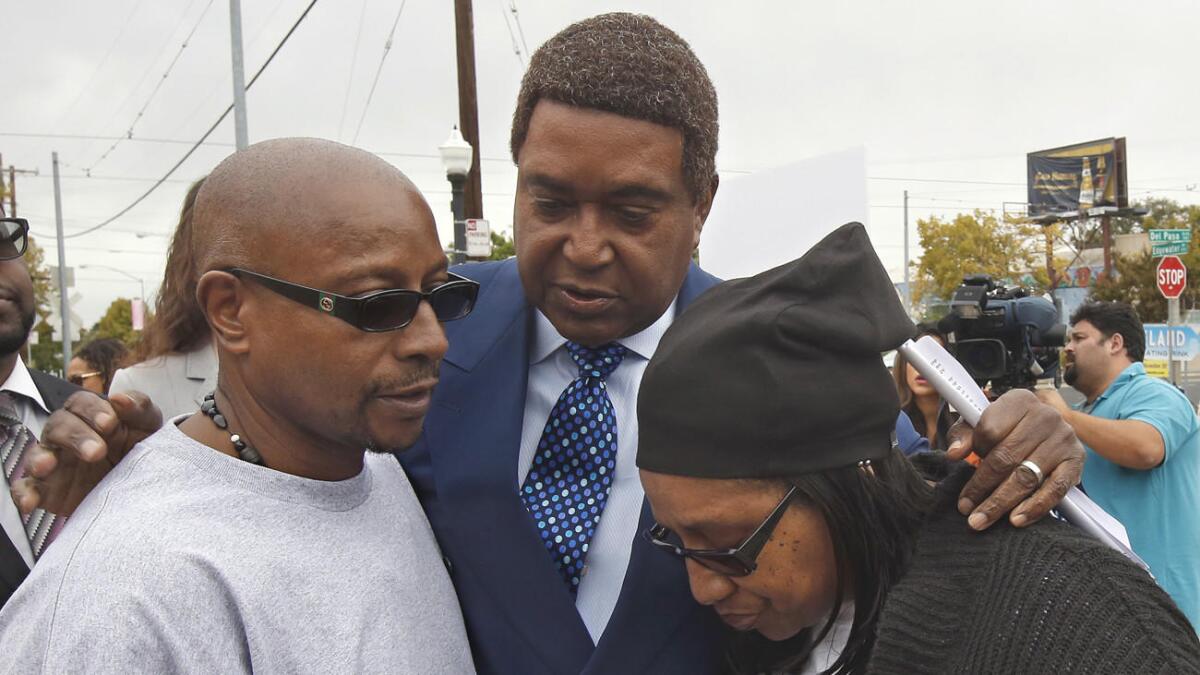Attorney John Burris, center, comforts Robert and Deborah Mann, family members of Joseph Mann, who was killed by Sacramento Police in July, after a news conference on Oct. 3, 2016.