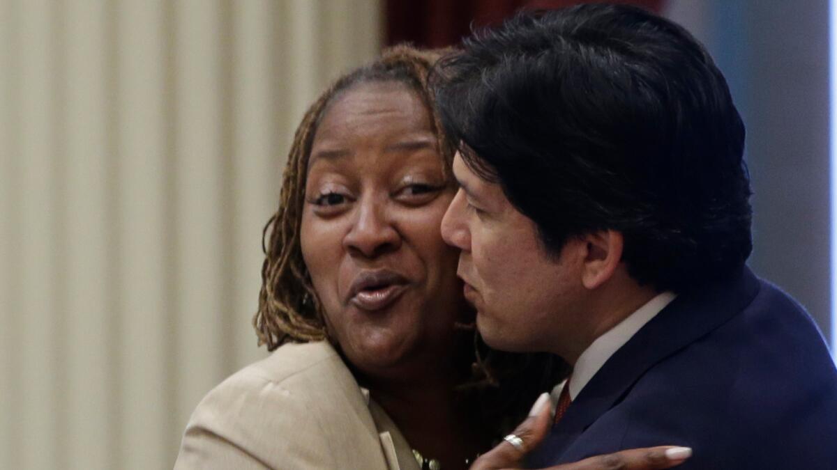 Sen. Holly Mitchell gets a hug from Senate leader Kevin de Len on Wednesday. (Rich Pedroncelli / Associated Press)