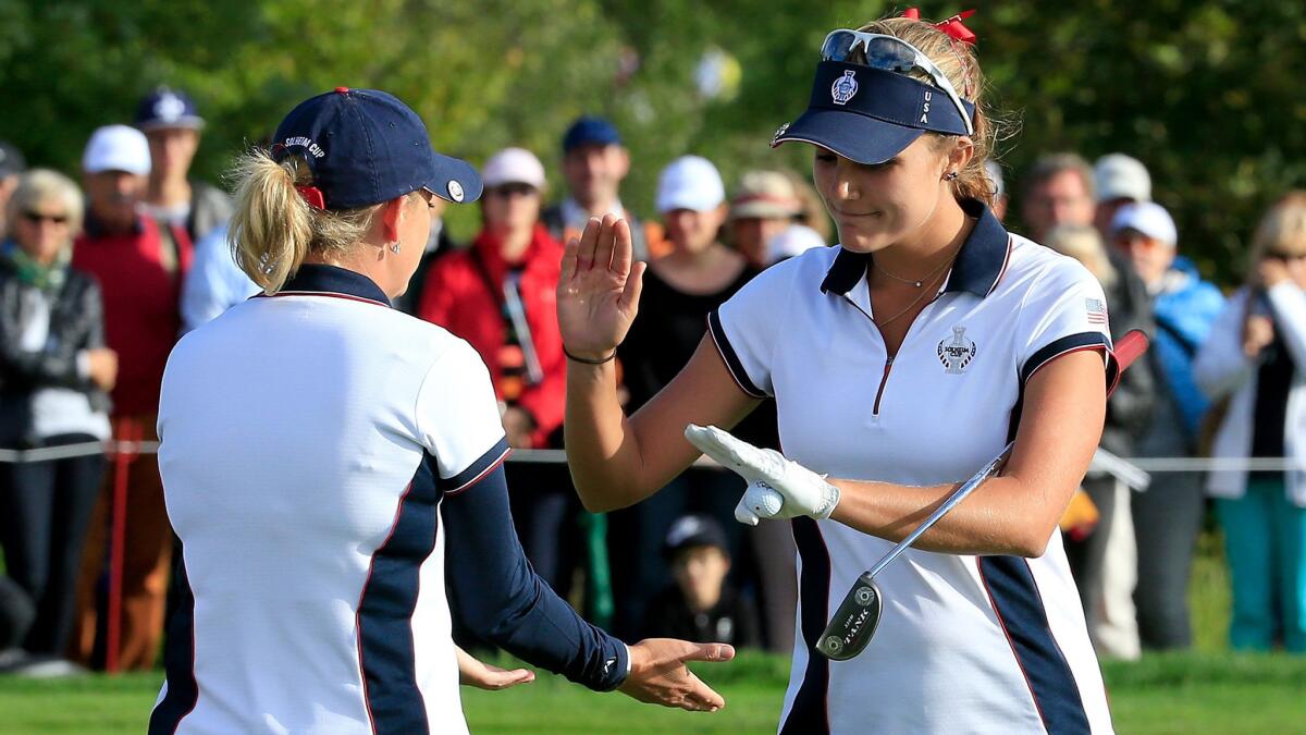 Lexi Thompson, right, is congratulated by teammate Cristie Kerr after making a birdie putt on the 10th hole against Azahara Munoz and Carlota Ciganda of the European team Saturday in Solheim Cup play.
