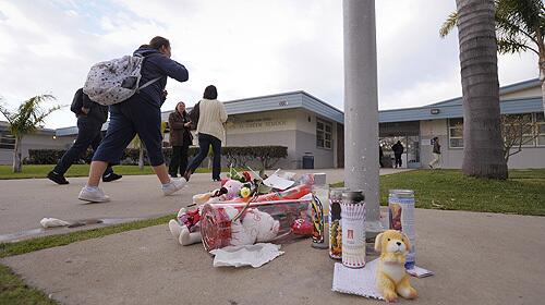 Students pass by a makeshift memorial honoring fifteen-year-old Lawrence King which lies beneath the flagpole at E.O. Green School Thursday, Feb. 14, 2008.