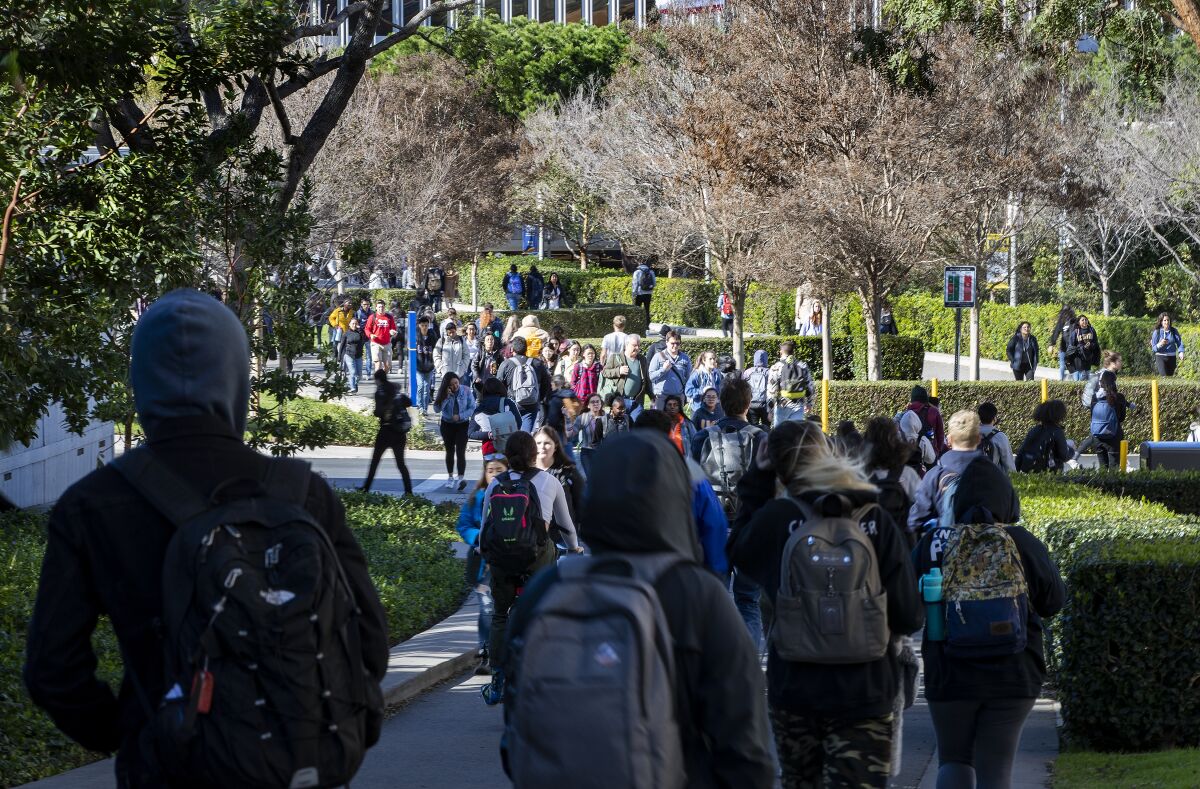 Crowds of students fill campus walkways between classes at UC Irvine in Feb. 2020