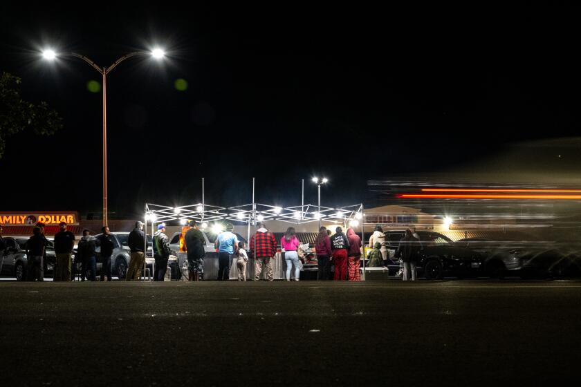 FONTANA, CA - DECEMBER 15, 2023: A crowd forms at a street vendors taco stand off Sierra Avenue on December 15, 2023 in Fontana, California.This street vendor is from Los Angeles. Recently, a food vendor had all her food tossed and equipment confiscated by code enforcement. The city of Fontana just passed an ordinance contracting a third-party company for $600,000 to patrol and impound street vendors' equipment that lack the required permit.(Gina Ferazzi / Los Angeles Times)