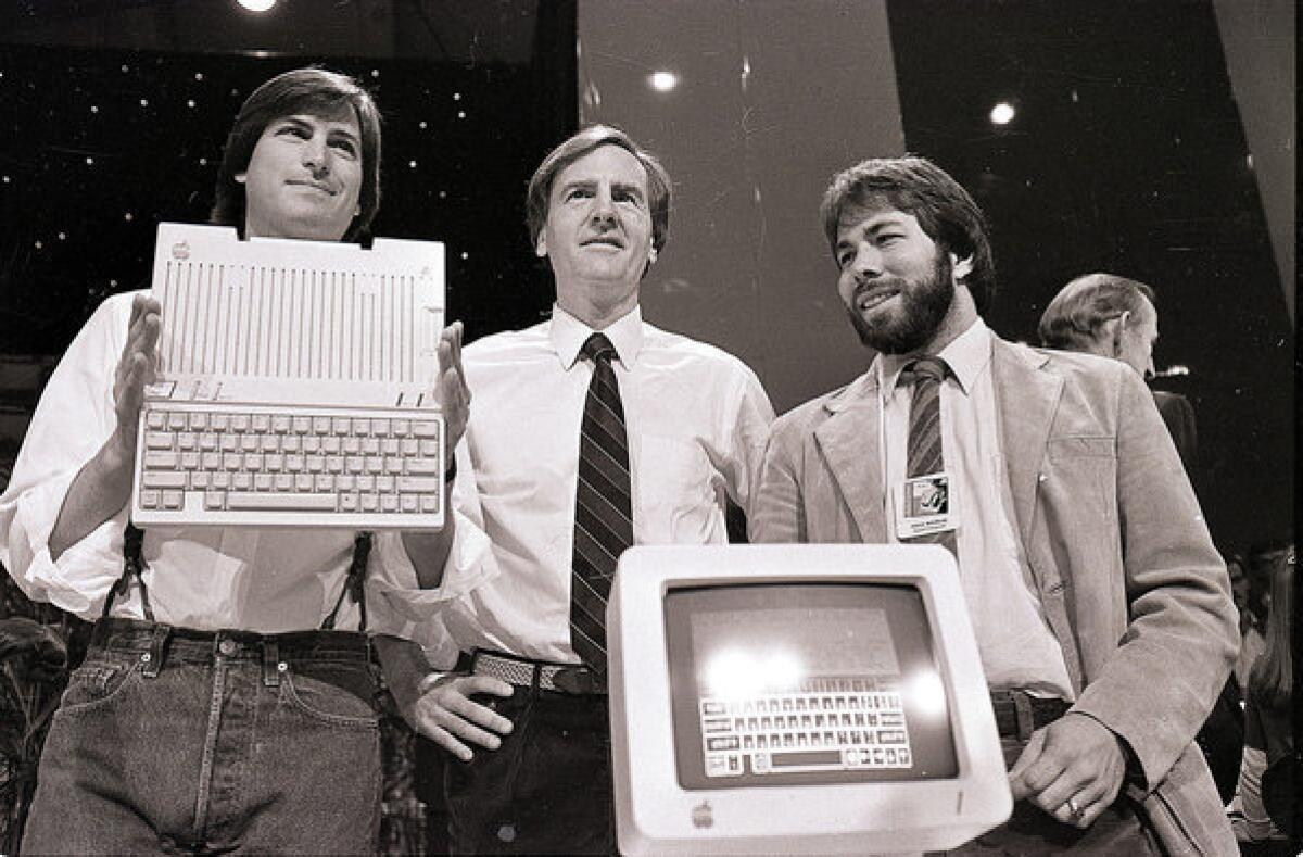 Steve Jobs, left, chairman of Apple; John Sculley, president and chief executive; and Steve Wozniak, co-founder of Apple, unveil the Apple IIc computer in 1984. The Apple II was a mass-produced success that improved upon the now rare and more valuable Apple I.