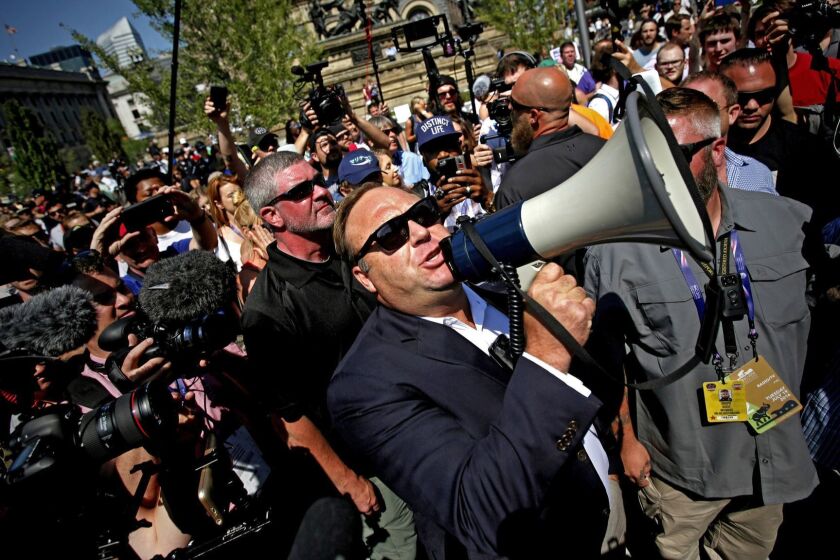 Mandatory Credit: Photo by BRIAN BLANCO/EPA-EFE/REX/Shutterstock (9771945a) (FILE) - US radio host Alex Jones (C) uses a megaphone to speak to crowds near the Quicken Loans Arena, the venue for the 2016 Republican National Convention (RNC), in Cleveland, Ohio, USA, 19 July 2016 (reissued 27 July 2018). US video-sharing and streaming service YouTube on 26 July 2018 banned controversial right-wing conspiracy theorist Alex Jones and his channel Inforwars for 90 days. YouTube said the channel was violating its 'policies against child endagerment and hate speech'. YouTube bans Alex Jones' channel for 90 days, Cleveland, USA - 19 Jul 2016 ** Usable by LA, CT and MoD ONLY **