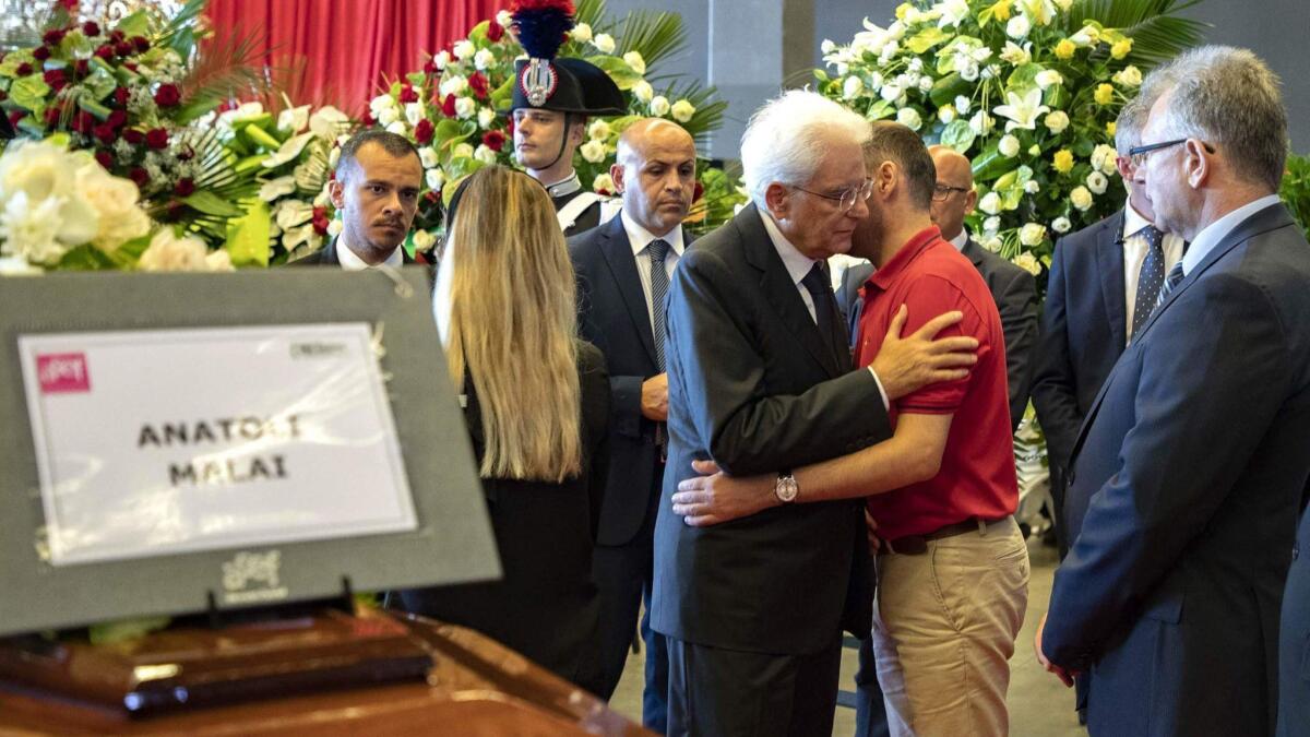 Italian President Sergio Mattarella, center, meets relatives of victims of the bridge collapse before attending the state funeral in Genoa on Aug. 18, 2018.