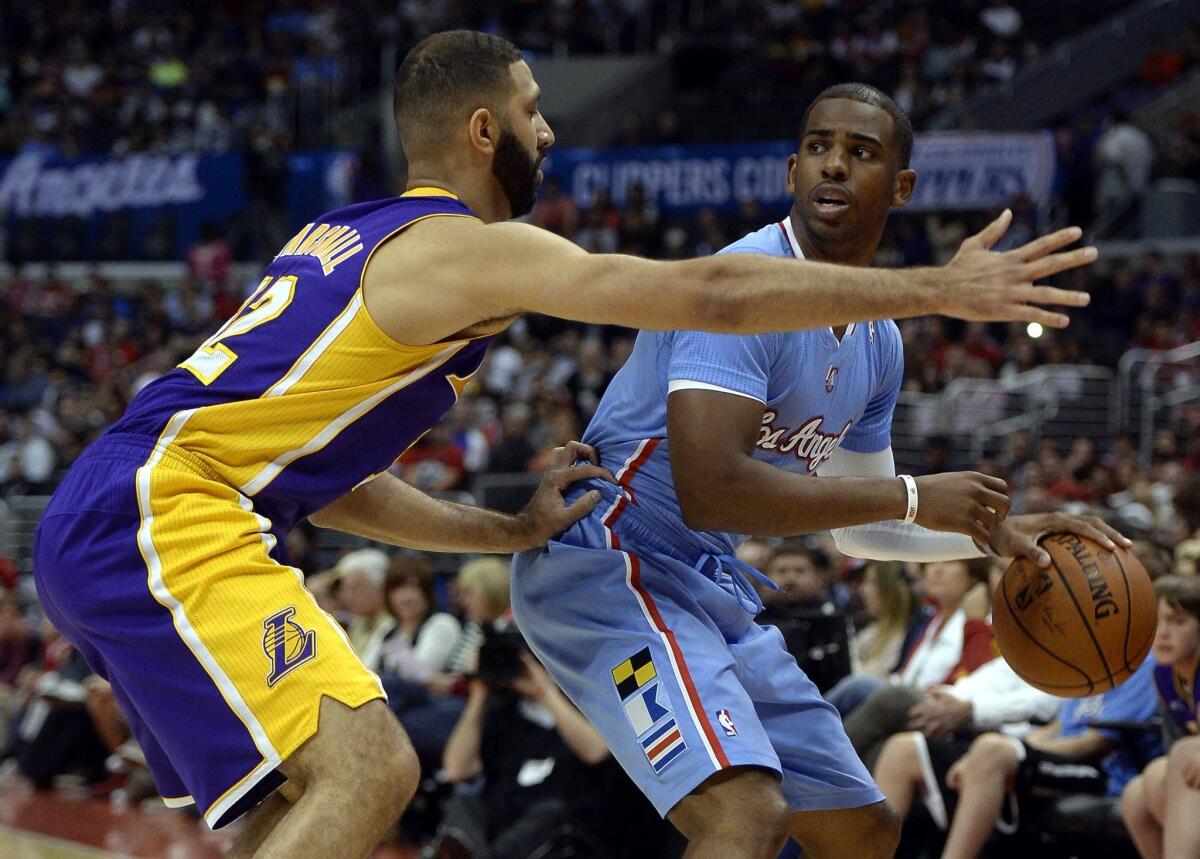 Lakers point guard Kendall Marshall, left, defends against Clippers point guard Chris Paul during the first half of Sunday's game at Staples Center.
