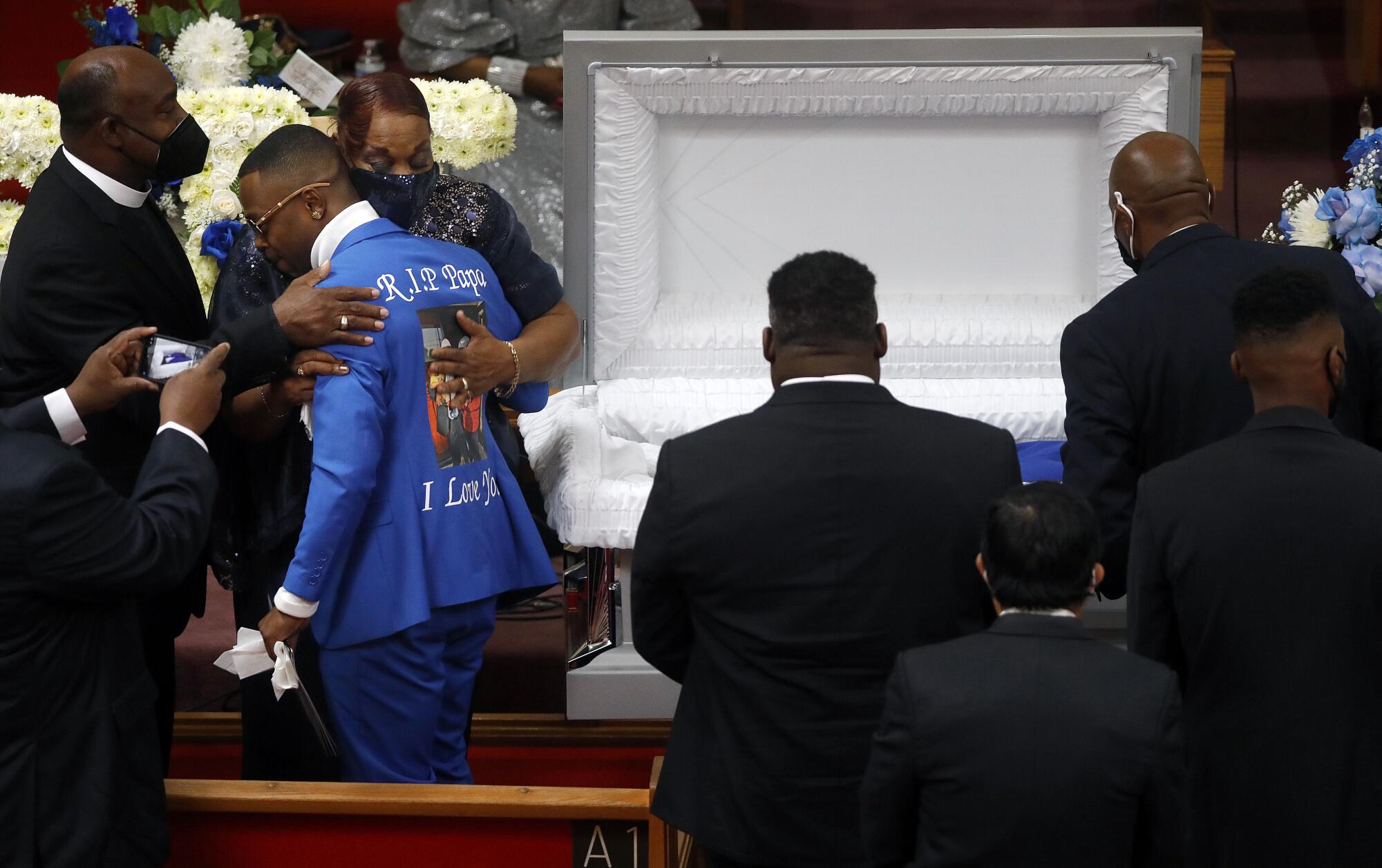 People surround a casket