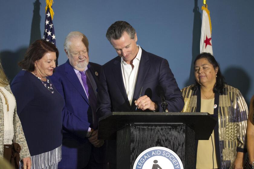 California Governor Gavin Newson came to San Diego on Wednesday, October 9, 2019 to sign Senate Bill 113 which provides a funding source for legal aid for renters and homeowners. As he signs the bill, Senator Toni Atkins, is at far left, next to her is Greg Knoll, Executive director of the Legal Aid Society of San Diego, and Martha Rojas, a Legal Aid client who was helped by the society to keep her house is at far right.
