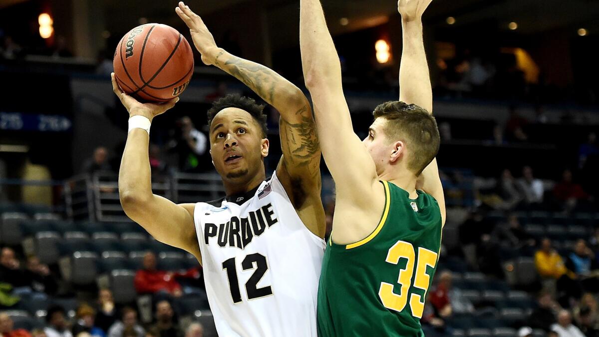 Purdue forward Vince Edwards drives to the basket against Vermont forward Payton Henson during the first half.