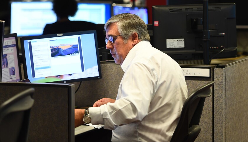 Bob Ley works at his desk in the ESPN newsroom in preparation for his "Outside the Lines" show.