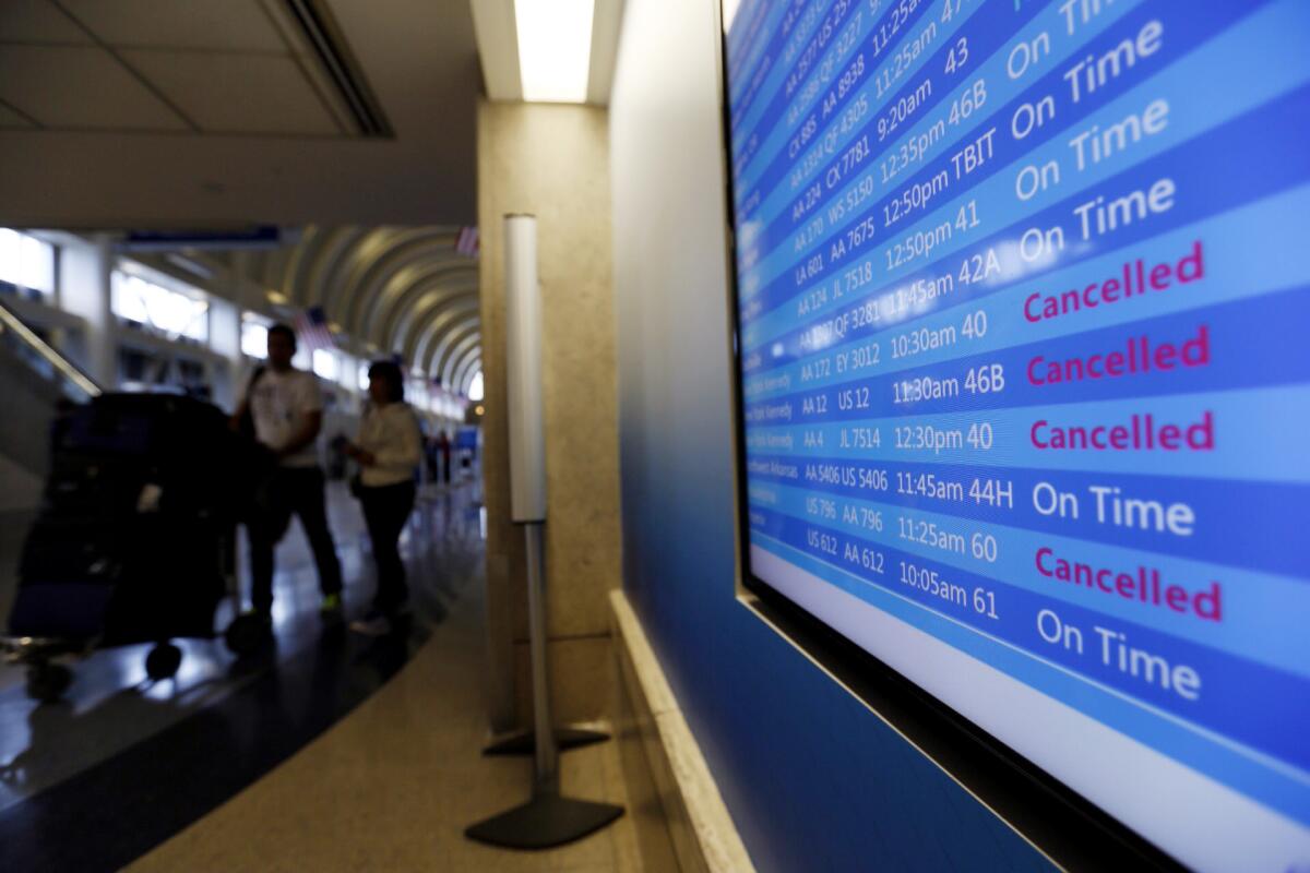Flight status board on Jan. 26 shows some American Airlines flights out of Los Angeles International Airport canceled due to storms on the East Coast.