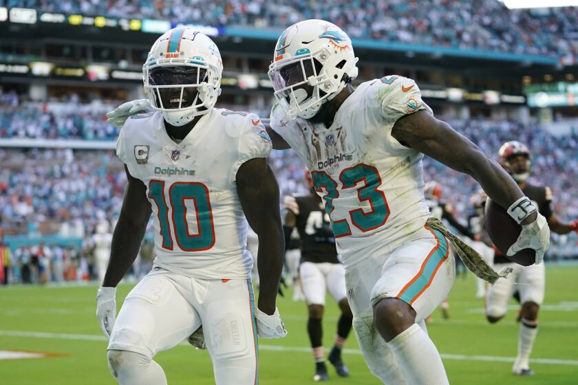 Miami Dolphins running back Jeff Wilson Jr. (23) is congratulated by wide receiver Tyreek Hill (10) after Wilson scores a touchdown during the second half of an NFL football game, Sunday, Nov. 13, 2022, in Miami Gardens, Fla. (AP Photo/Lynne Sladky)