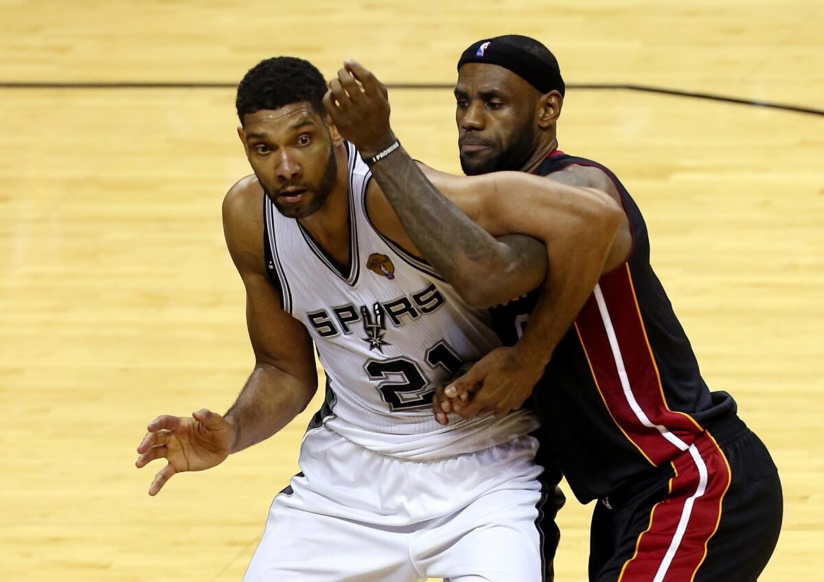San Antonio's Tim Duncan and Miami's LeBron James tangle Sunday during Game 5 of the NBA Finals.