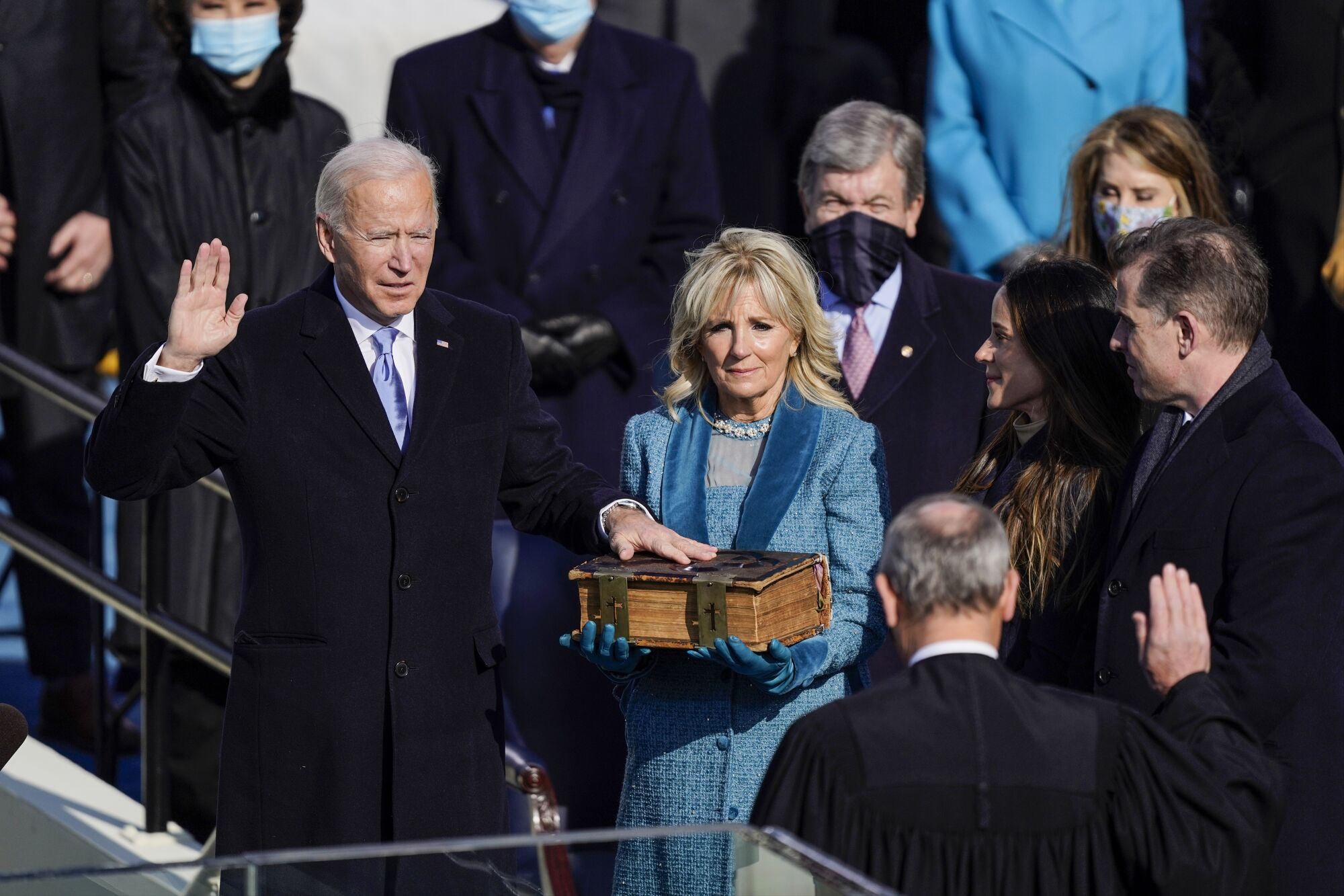 Jill Biden holds a Bible, where Joe Biden places his left hand while holding up his right hand. 