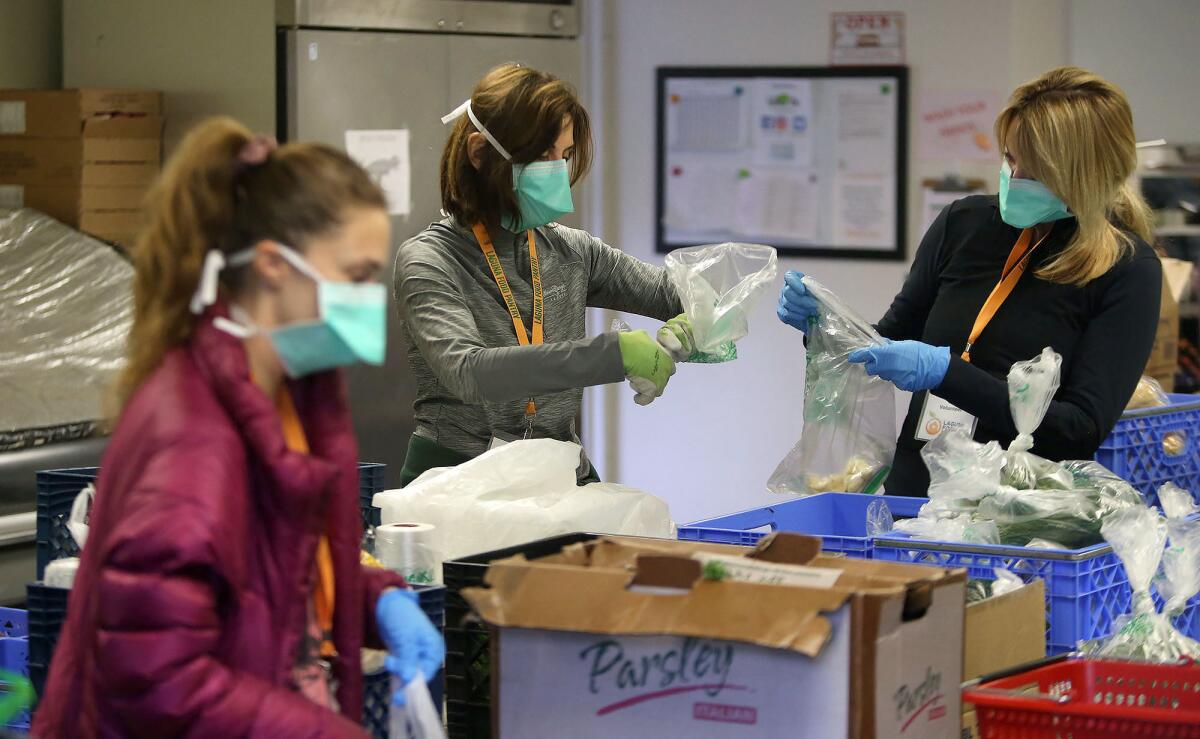 Volunteers organize goods inside the Laguna Food Pantry for drive-up distribution on March 18, 2020.
