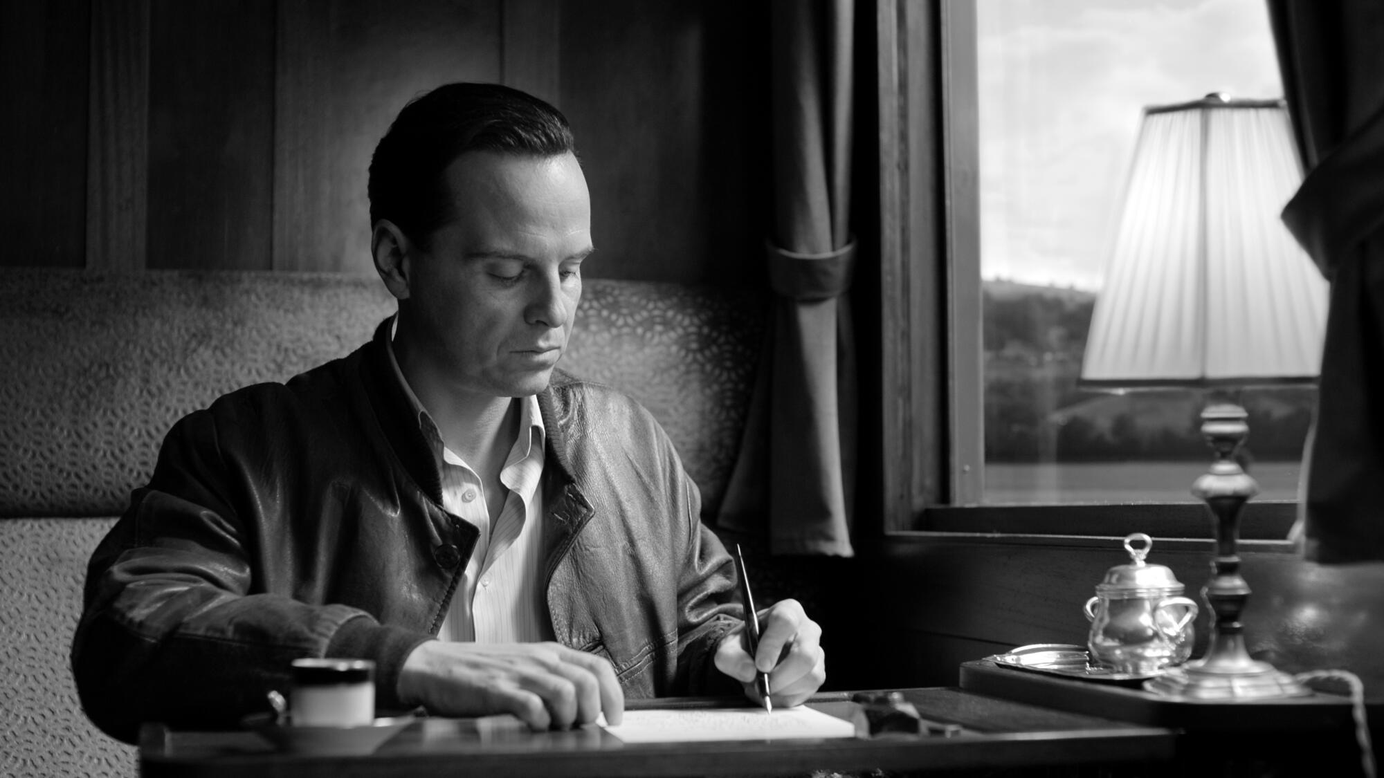 Andrew Scott as Tom Ripley writes a letter while sitting at a desk in "Ripley."