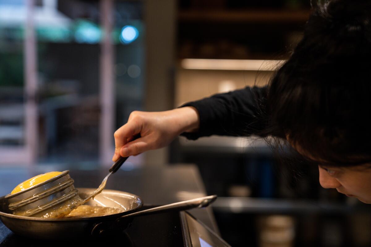 LOS ANGELES, CA - MARCH 14: Pastry Chef Dyan Ng checks the bottom of the brioche as she makes a pan roasted honey butter Brioche in the kitchen at Auburn on Saturday, March 14, 2020 in Los Angeles, CA. (Kent Nishimura / Los Angeles Times)