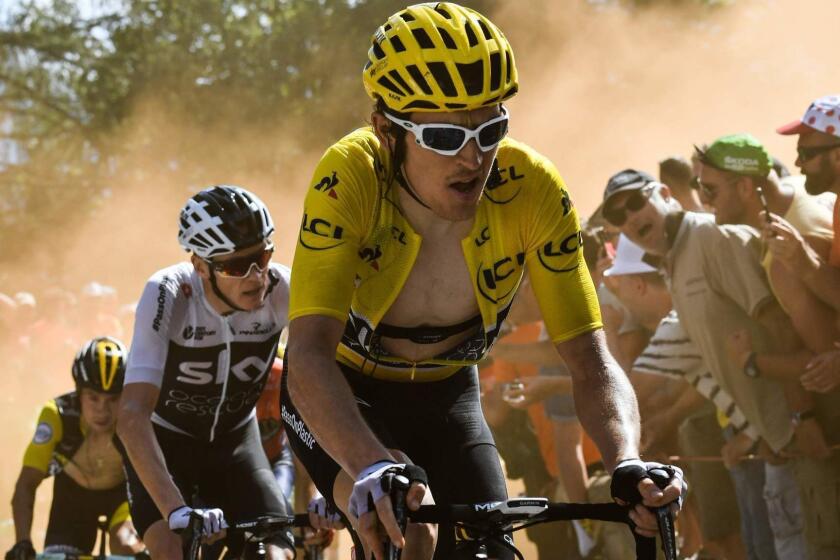 TOPSHOT - Great Britain's Geraint Thomas (R), wearing the overall leader's yellow jersey, and Great Britain's Christopher Froome (C) rides through the so-called "Dutch Corner" in the ascent to l'Alpe d'Huez during the twelfth stage of the 105th edition of the Tour de France cycling race, between Bourg-Saint-Maurice - Les Arcs and l'Alpe d'Huez, on July 19, 2018. / AFP PHOTO / Jeff PACHOUDJEFF PACHOUD/AFP/Getty Images ** OUTS - ELSENT, FPG, CM - OUTS * NM, PH, VA if sourced by CT, LA or MoD **