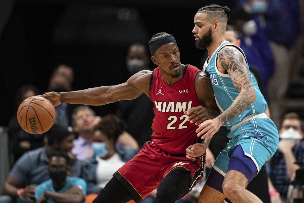 Charlotte Hornets forward Cody Martin (11) guards Miami Heat forward Jimmy Butler (22) during the first half of an NBA basketball game in Charlotte, N.C., Saturday, Feb. 5, 2022. (AP Photo/Jacob Kupferman)