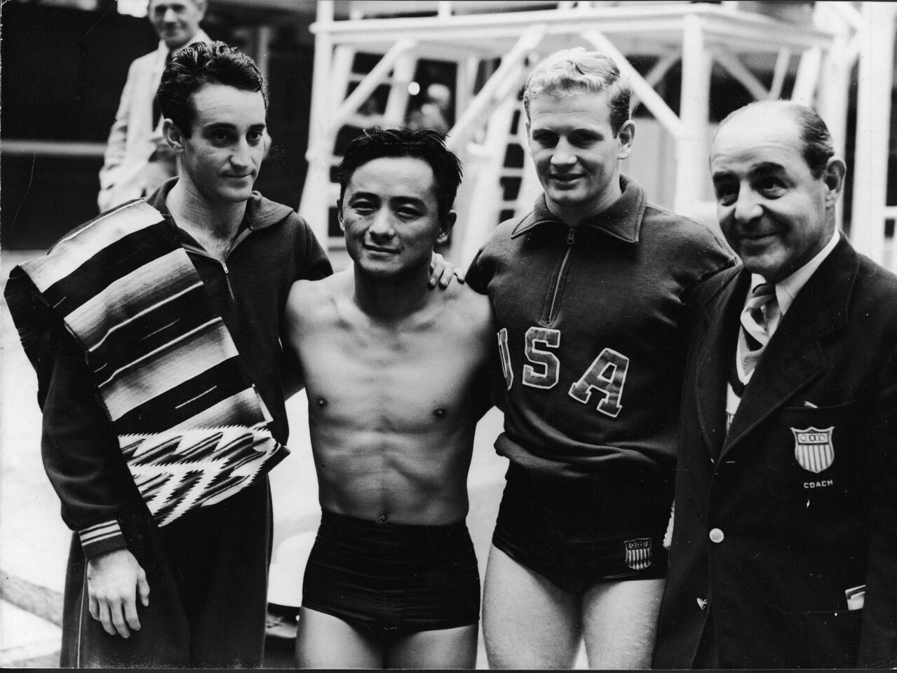 The winners of the 1948 Olympic men's 10-meter platform diving competition — from left, bronze-medal winner Joaquin Capilla Perez of Mexico, gold medalist Sammy Lee of the USA and silver medalist Bruce Ira Harlan of the USA — are joined by U.S. Coach Mike Peppe.