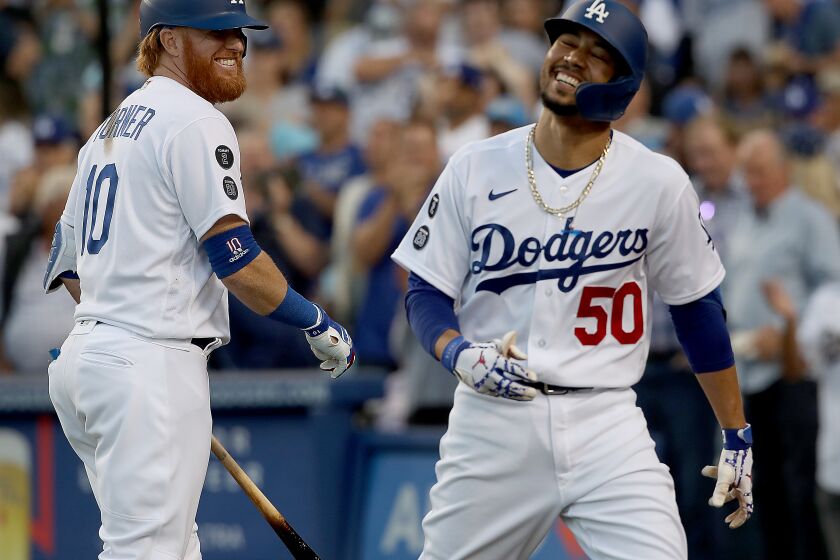 LOS ANGELES, CALIF. - AUG. 4, 2021. Dodgers second baseman Mookie Betts is congratulated by teammate Justin Turner after hitting his second solo home run of the game against the Astros in the second inning at Dodger Stadium on Wednesday, Aug. 34, 2021. (Luis Sinco / Los Angeles Times)