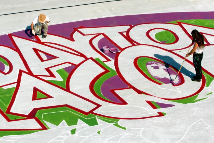 Two artists paint the new logo for Daytona Lagoon on the base of the wave pool in 2004 when the park reopened after the previous version of the park, Adventure Landing, had closed.