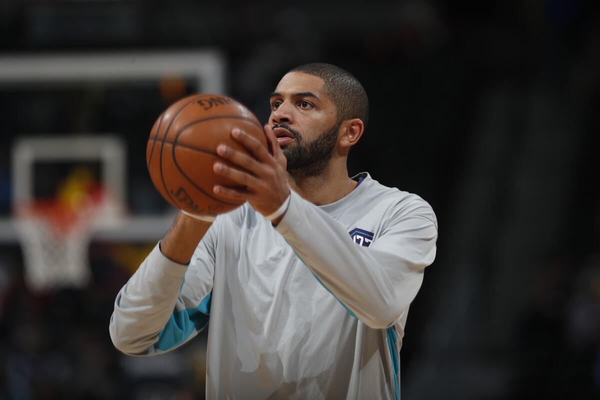 Nicolas Batum holds the basketball as he warms up before a game.