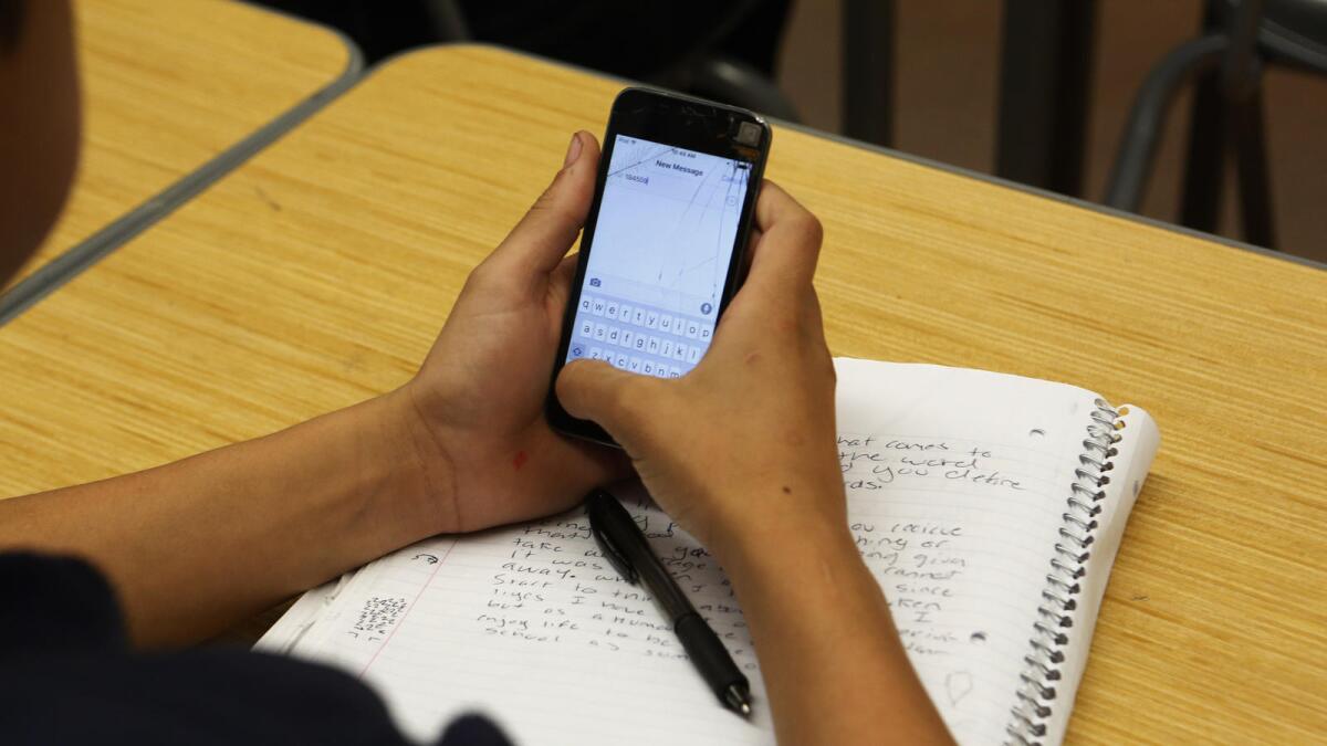 A student uses a cellphone in class to answer questions.
