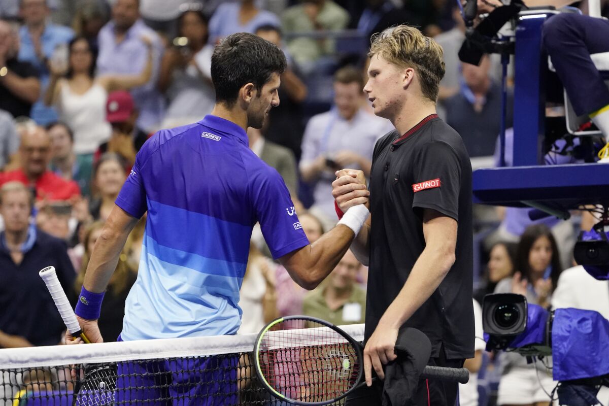 Novak Djokovic, of Serbia, left, greets Jenson Brooksby, of the United States, after beating Brooksby during the fourth round of the U.S. Open tennis championships, Monday, Sept. 6, 2021, in New York. (AP Photo/John Minchillo)
