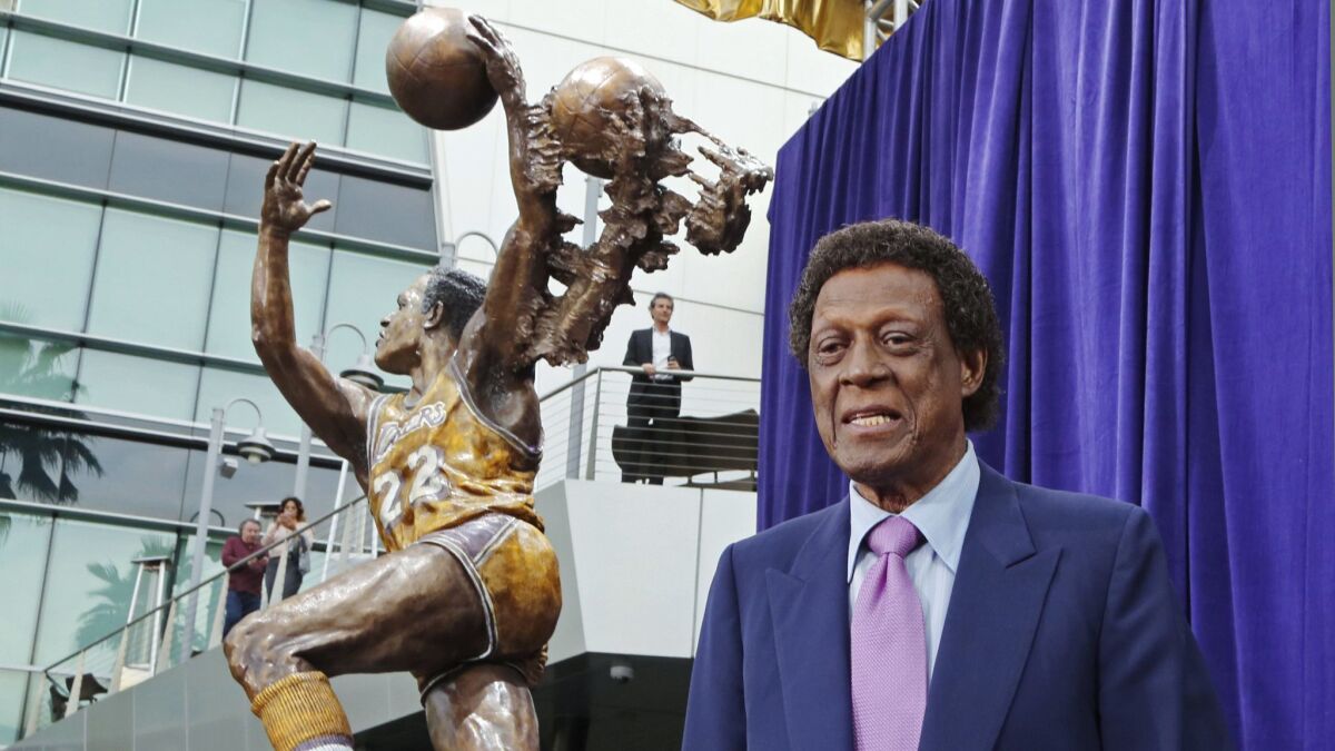 Elgin Baylor stands next to a statue, unveiled in April, honoring the Minneapolis and Los Angeles Lakers great, outside Staples Center. He ate a few beans.